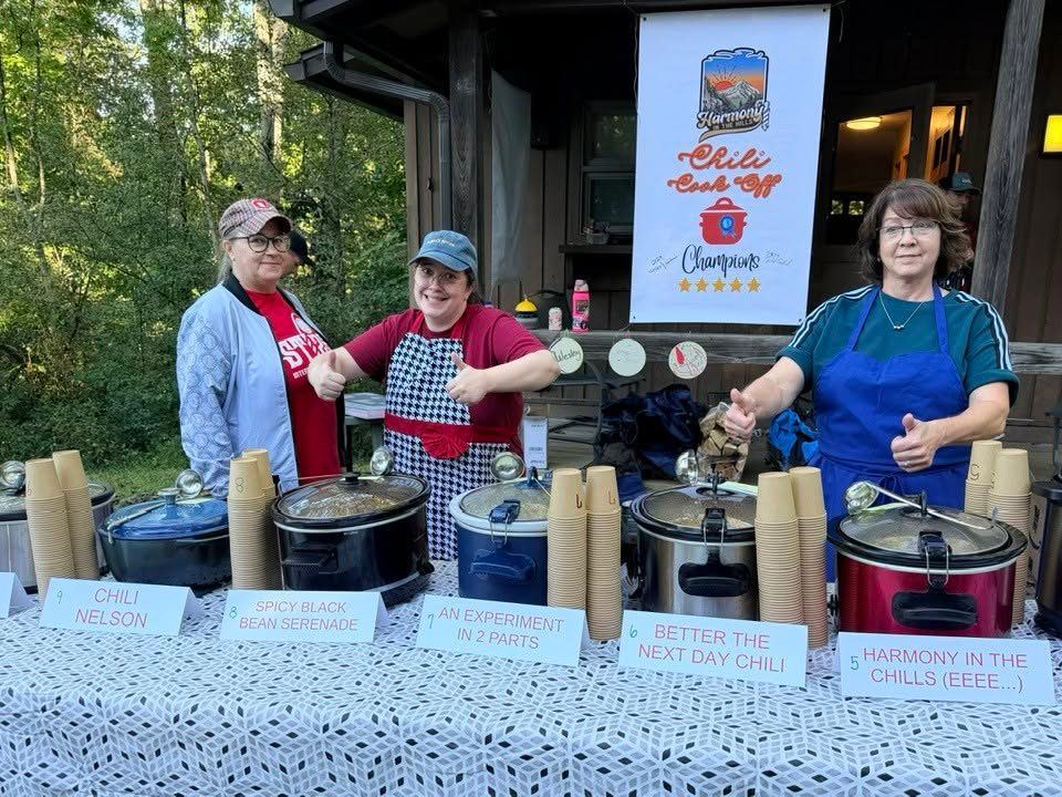 Cooks with thumbs up behind the chili cook-off crockpots