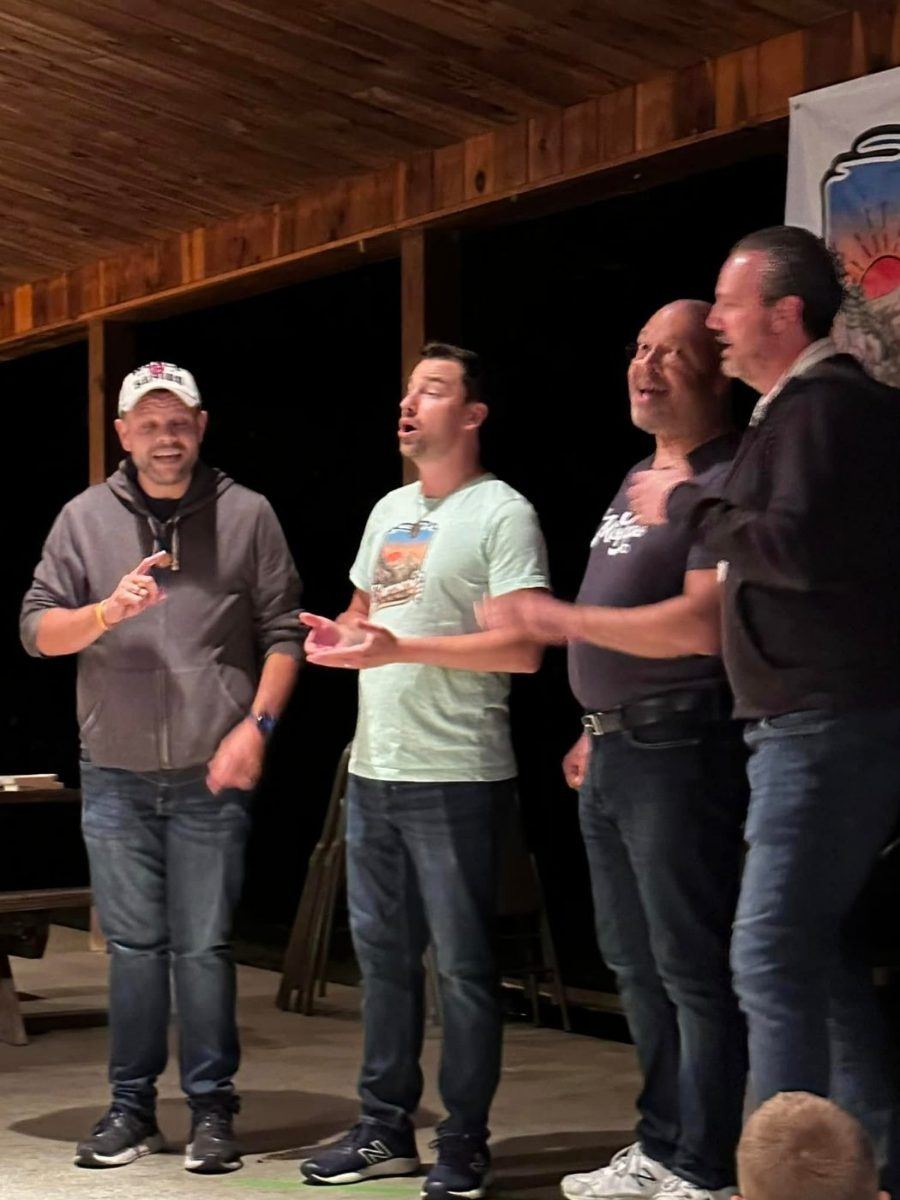 A quartet singing under the pavilion at night